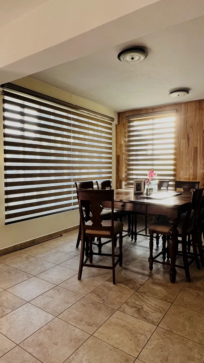Persiana Sheer Elegance en tono madera en un comedor
